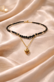 Elegant black beaded neckpiece with golden heart charm